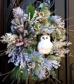 a wreath with an owl and pine cones