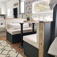 a living area with couches and a table in front of a window that looks out onto the street