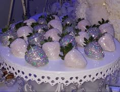 there are many strawberries on the table with silver sequins and green leaves