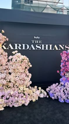 there are many flowers on display in front of the kardashians sign at the mall