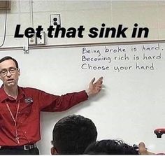 a man standing in front of a whiteboard with writing on it and people sitting around him