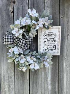 a wreath with some flowers on it and a sign that says someone is in heaven