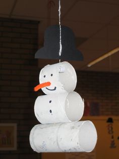 an image of a snowman made out of toilet paper rolls hanging from the ceiling