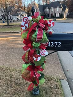 a mailbox decorated with red, green and white ribbons