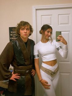 a man and woman dressed up as star wars characters standing in front of a door