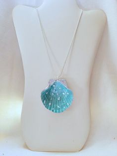 This is a painted shell necklace with  sea shaped appliques onto a resin foundation. Blue Shell-shaped Ocean-inspired Necklace, Ocean-inspired Turquoise Pendant Necklace, Ocean-inspired Blue Shell-shaped Necklace, Blue Ocean-inspired Shell-shaped Necklace, Blue Shell-shaped Necklaces, Turquoise Shell Necklace, Ocean-inspired, Turquoise Shell Necklace Ocean-inspired, Turquoise Shell Necklace, Handmade Blue Shell Necklaces