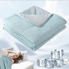 a woman laying on top of a bed next to an ice block pillow and blanket