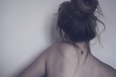 a woman with a cross tattoo on her back