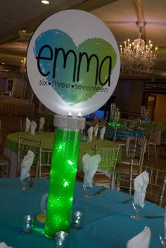 a green vase sitting on top of a table covered in white napkins and silverware