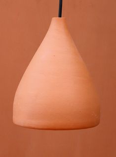 a brown vase with a black handle hanging from it