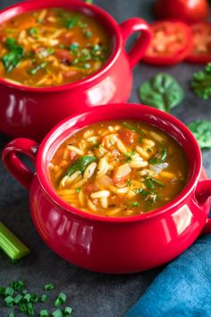 two red bowls filled with soup on top of a table