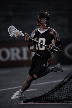 a lacrosse player is running with the ball