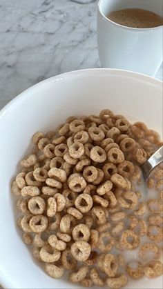 a bowl full of cereal next to a cup of coffee