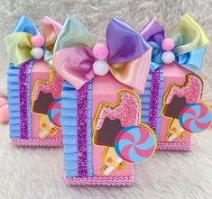 three candy boxes decorated with bows and lollipops