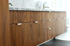 a bathroom with marble counter tops and wooden cabinets