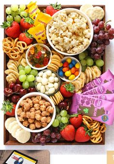 the movie snack board is full of snacks, fruit, and crackers to make the best ever