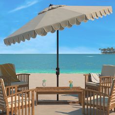 an umbrella and chairs on the beach near the ocean