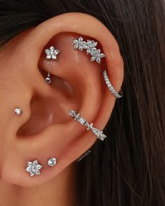 a woman's ear with three different piercings