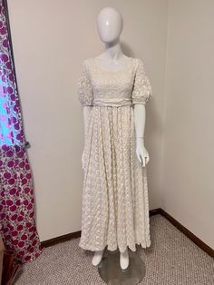 a mannequin wearing a white dress in a room