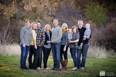 a family poses for a photo in front of some trees