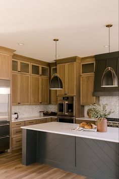 a large kitchen with wooden cabinets and stainless steel appliances, along with an island in the middle