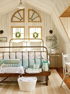 a bed sitting in a bedroom next to a window with wreaths on the windowsill