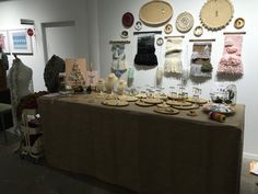 a table covered with plates and bowls in front of pictures on the wall behind it