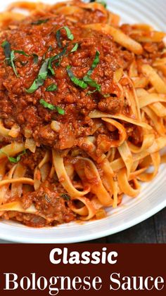 a white plate topped with pasta covered in sauce and garnished with parsley