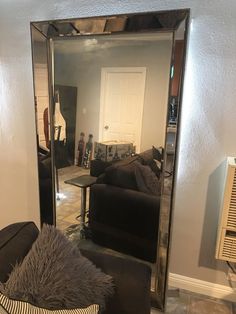 a living room filled with furniture and a large mirror over the top of a couch