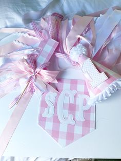 some pink and white ribbons on top of a table with the word scp in it