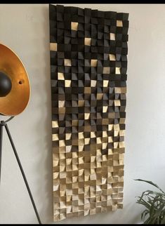 a black and gold wall hanging next to a potted plant