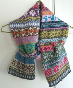 two knitted scarves hanging on a hook