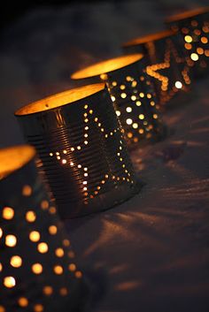 many lit candles are lined up on a table