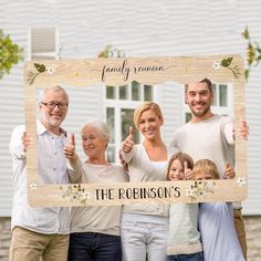 a family posing for a photo in front of a house with the name robinson's on it