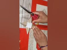 a person cutting paper with scissors on top of a piece of cardboard that has been cut into smaller pieces