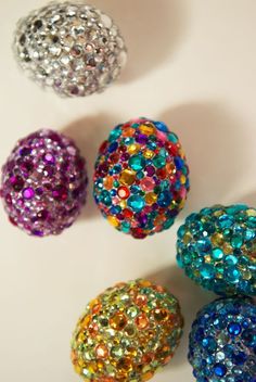 five different colored beads on a white surface