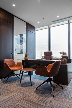 two chairs and a table in an office with large windows overlooking the cityscape