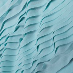 a close up view of the fabric with wavy waves on it's surface, in light blue