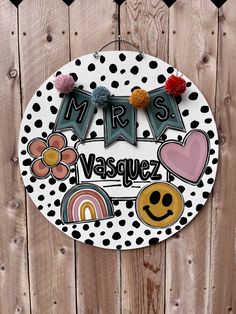 a sign that says mrs vasquez on the side of a wooden fence with black and white polka dots