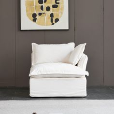 a white chair sitting in front of a painting