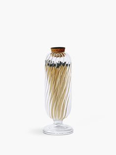 a glass vase filled with lots of wooden sticks