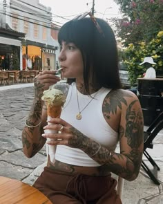 a woman with tattoos holding an ice cream cone