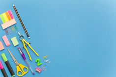 various office supplies laid out on a blue surface