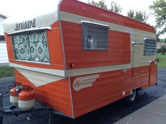 an orange and white trailer is parked on the street