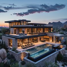 an aerial view of a modern house with pool in the foreground and mountains in the background