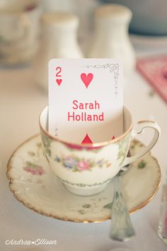 a table topped with a cup and saucer filled with tea cups covered in cards