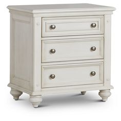 a white dresser with three drawers and two doors on the bottom, in front of a white background