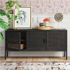 the sideboard is next to a plant and pictures