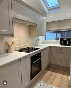 a kitchen with white cabinets and an oven