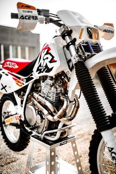 a white dirt bike parked on top of a metal stand